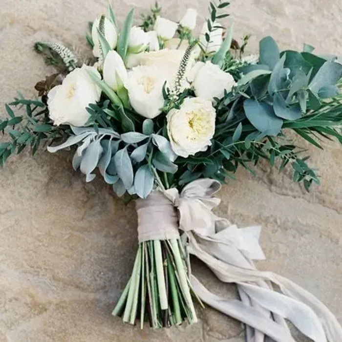 A refined all-white bouquet with eucalyptus and silk ribbon